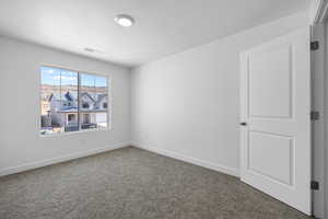 Carpeted empty room with baseboards