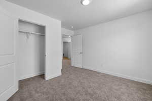 Unfurnished bedroom with light colored carpet and a closet