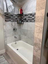 Bathroom with shower / bath combination and baseboards