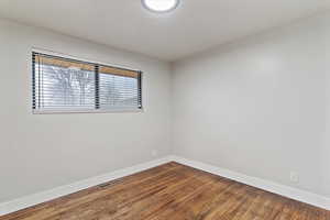 Spare room featuring wood finished floors and baseboards