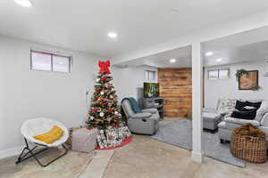 Sitting room with unfinished concrete flooring and recessed lighting