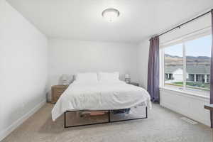 Bedroom with light colored carpet and baseboards
