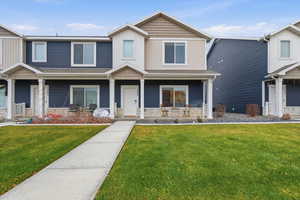 View of front of property featuring a porch, a front lawn, and board and batten siding