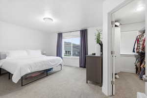 Bedroom featuring light carpet