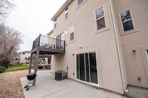 Back of house with a patio, stucco siding, and a deck