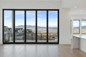 Main floor living room with a mountain view, plenty of natural light, light wood-style floors, and recessed lighting