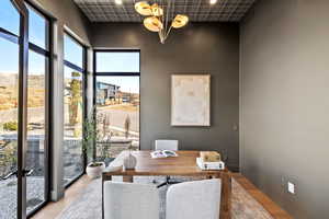 Office with wood finished floors, plenty of natural light, and a chandelier