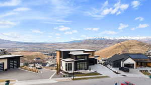 View of front of house with a mountain view, stucco siding, and driveway