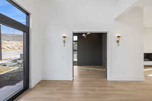 Unfurnished dining area featuring light wood finished floors and a high ceiling