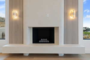 Detailed view of wood finished floors and a fireplace with raised hearth