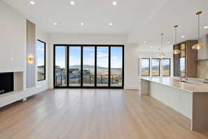 Main floor living room with a mountain view, light wood-style flooring, and recessed lighting