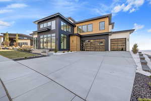 Contemporary house featuring concrete driveway and an attached garage
