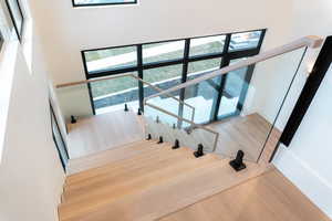Stairway with wood finished floors and healthy amount of natural light