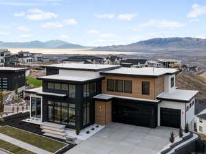 Contemporary home featuring a mountain view, a residential view, concrete driveway, a garage, and stucco siding