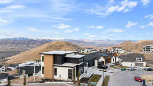 View of front of property with a residential view, a mountain view, and a patio area