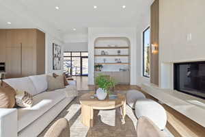 Living room with a fireplace, wood finished floors, plenty of natural light, and recessed lighting