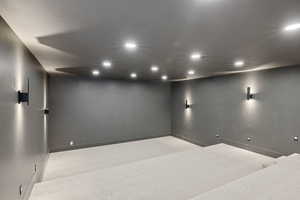 Carpeted cinema room with recessed lighting and baseboards