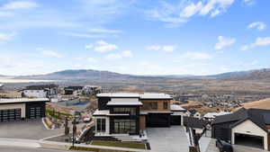 View of front of property featuring a mountain view, a residential view, a garage, and stucco siding