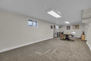 Living area in basement featuring carpet and baseboards