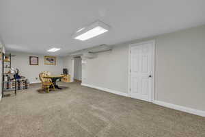 Living area in basement featuring carpet and baseboards