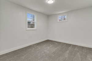 Carpeted empty room featuring baseboards