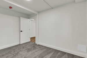 Carpeted empty room featuring baseboards