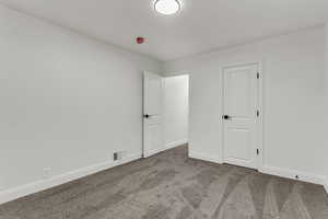 Unfurnished bedroom featuring carpet floors and baseboards