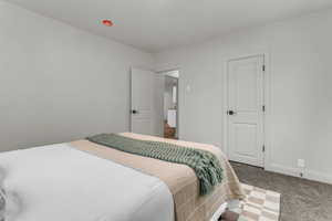 Bedroom featuring carpet floors and baseboards