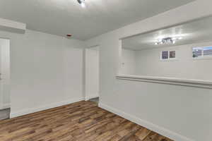 Spare room with a textured ceiling and wood finished floors