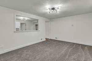 Carpeted spare room with a textured ceiling