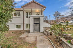 View of front facade with stucco siding and a shingled roof