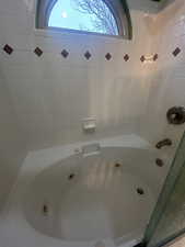 Bathroom with a jetted tub and plenty of natural light