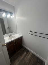 Bathroom featuring wood finish floors and vanity with a skylight above.