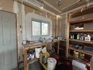 3 car garage with door, window, built in shelves, and workbench