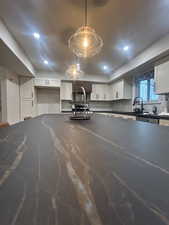 Kitchen featuring white cabinetry, backsplash, hanging light fixtures, laminum countertops, and recessed lighting