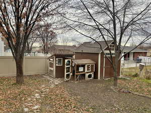 Back of property with a fenced yard, shed, and chicken coupe