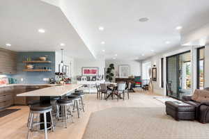 Kitchen featuring a kitchen breakfast bar, open floor plan, a peninsula, decorative backsplash, and recessed lighting