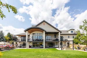 Rear view of house featuring a balcony, a patio area, and stucco siding