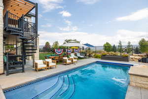 View of pool featuring a patio, stairs, a balcony, and outdoor lounge area