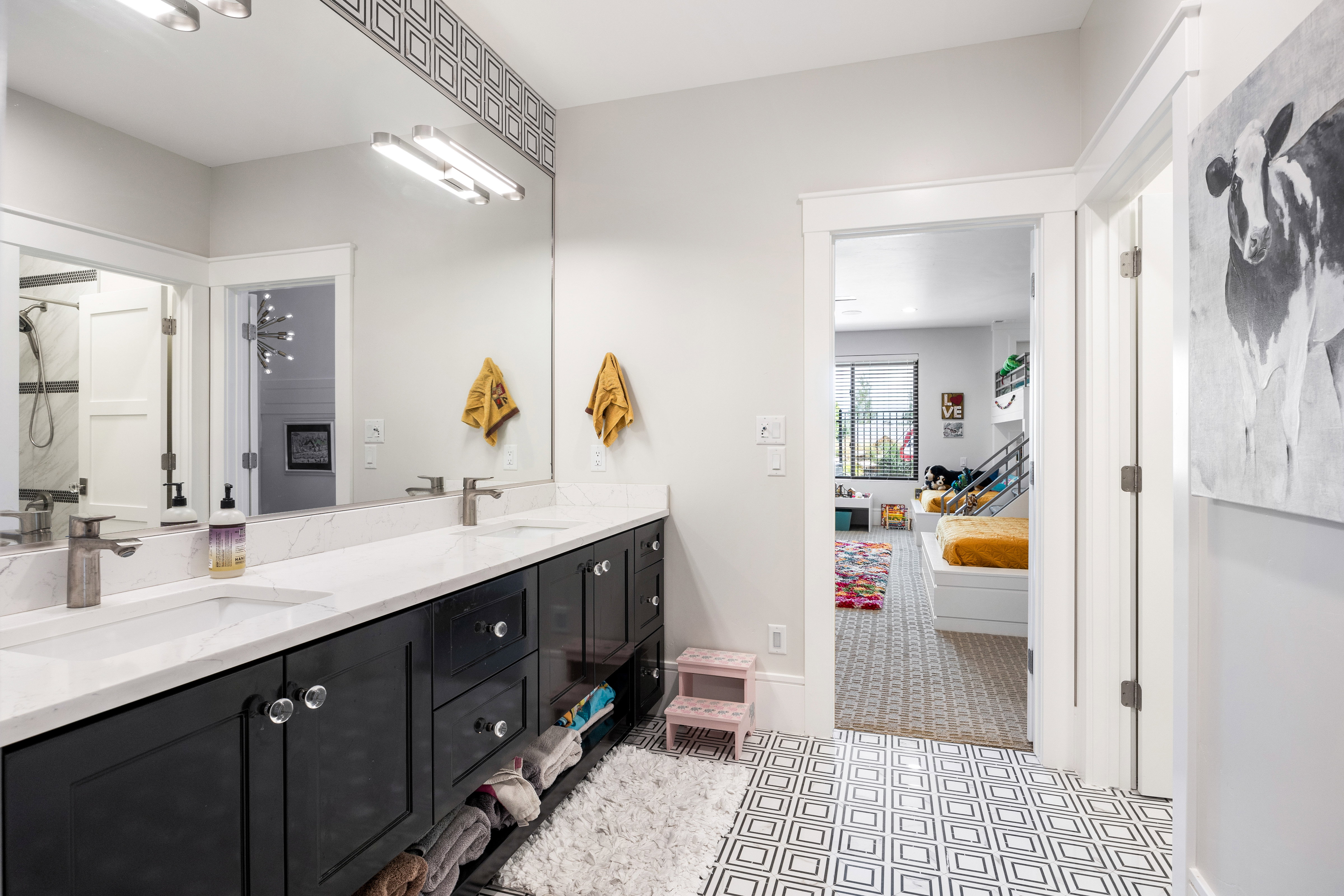 Ensuite bathroom with double vanity, a shower, and light flooring