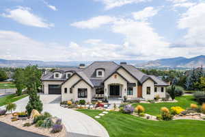 View of front of property featuring a mountain view, concrete driveway, a front yard, a standing seam roof, and a garage