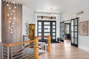 Entrance foyer featuring a barn door and wood finished floors