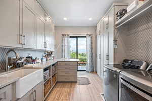 Laundry room featuring washer and dryer, light wood-style flooring, recessed lighting, and cabinet space