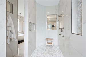 Full bath with a marble finish shower