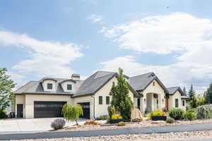 French provincial home featuring driveway, an attached garage, stucco siding, and a tile roof