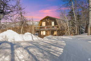 View of front of house featuring a gambrel roof and a deck