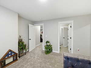 Bedroom with light colored carpet and baseboards