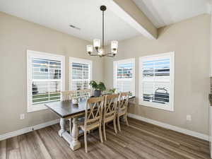 Dining space featuring beam ceiling, a chandelier, and light wood-style flooring