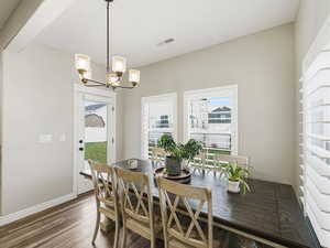 Dining area with wood finished floors and a chandelier