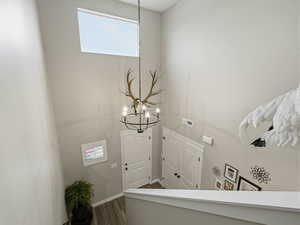 Foyer featuring a chandelier, a towering ceiling, and dark wood finished floors